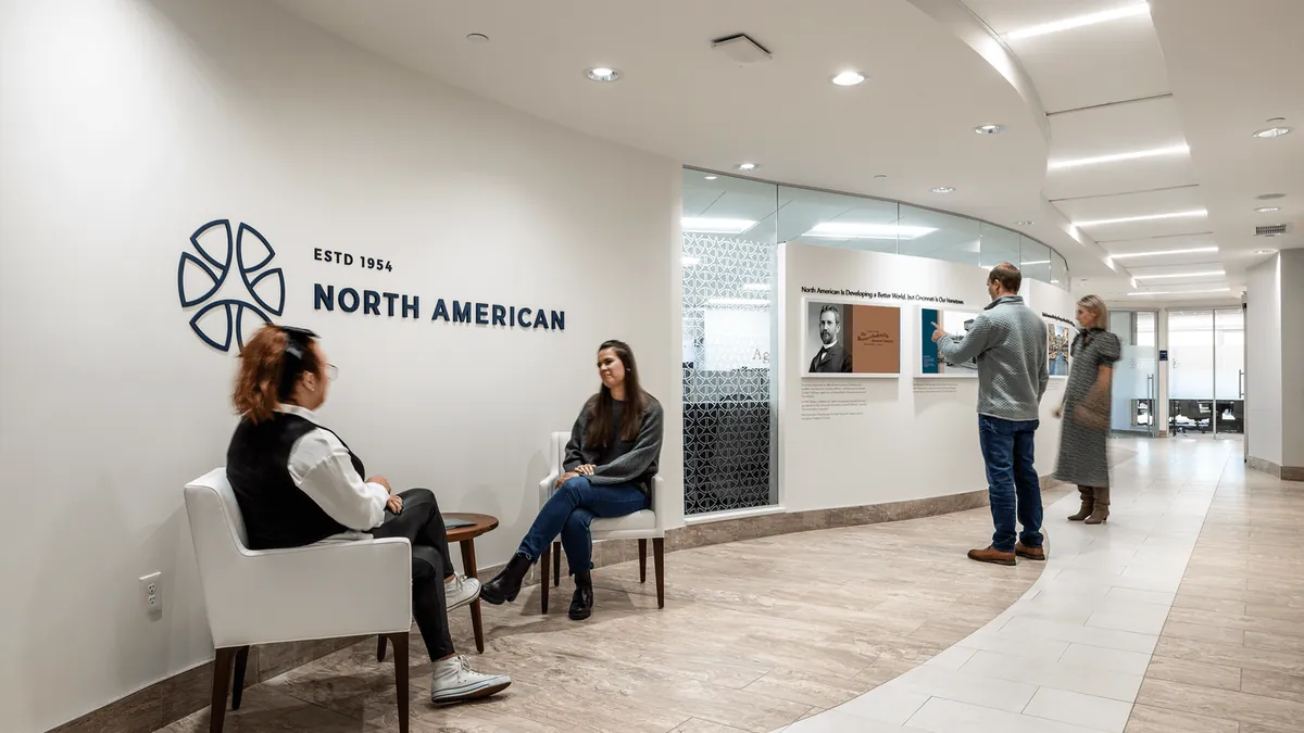 Office lobby with recessed ceiling lighting, seating and a wall-mounted company logo